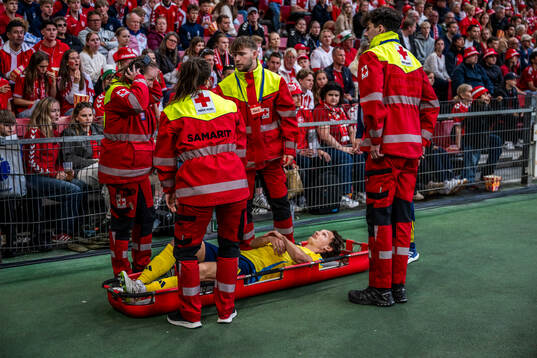 Hjalmar Ekdal of Sweden is carried of the pitch