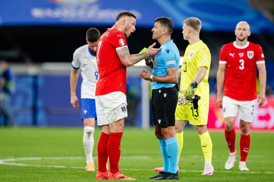 Marko Arnautovic of Austria and referee Jesus Gil Manzano