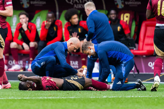 Jeremy Doku of Belgium receives care