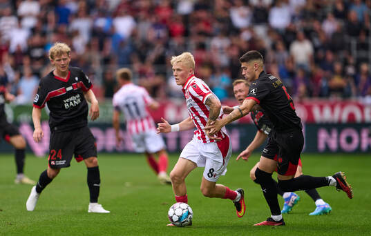  Fotboll, Danska Ligan, Midtjylland - Ålborg: HERNING, DENMARK - AUGUST 03: Melker Widell of AaB Aalborg is chased by Emiliano Martínez of FC Midtjylland during the danish 3F Superliga match between FC Midtjylland and AaB Aalborg at MCH Arena on August 3, 2024 in Herning, Denmark. (