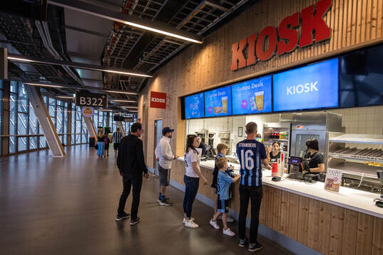 Glest med besökare vid en kiosk på Tele2 Arena