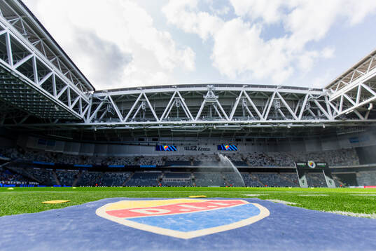 En matta med Djurgårdens klubbmärke på kostgräset på Tele2 Arena