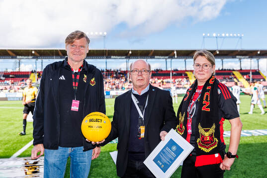 Östersund FK Elitfotbolls ordförande Tom Pripp får en jubileumsboll med anledning av Allsvenskans 100 års jubileum av Hans Larsson från SEF, th på bild Östersunds akademichef Camilla Eriksson