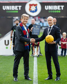 Örgrytes ordförande Terje Johansson tar emot en jubileumsboll av Petter Grundel, SEF, för att fira Allsvenskan 100 år