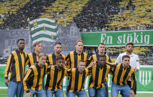 Hammarbys startelva poserar för en bild framför supportarnas tifo