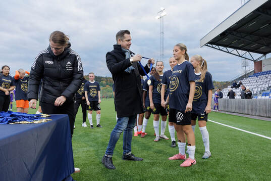 Linn Eriksson och Axel Pershagen delar ut medaljer