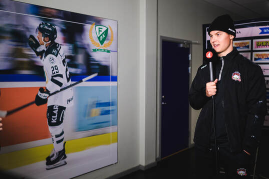Malmö Redhawks Fredrik Händemark blir intervjuad om senast när han spelade mot Färjestads Oskar Steen T.v i bild på affischen, och hamnade i Färjestads spelarbås