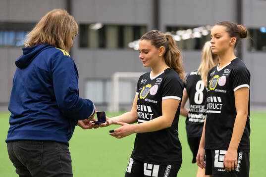 Marie Svensson delar ut en silvermedalj till Uppsalas Lova Tomic