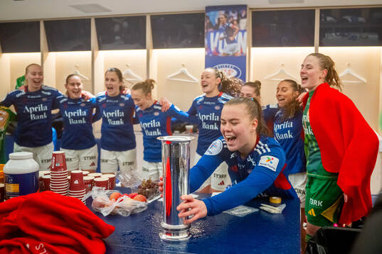 Olaug Tvedten and players of Vålerenga celebrate with the trophy in the dressing room