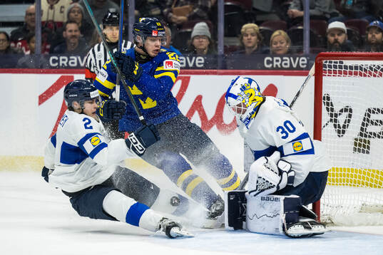Mitja Jokinen and goaltender Petteri Rimpinen of Finland