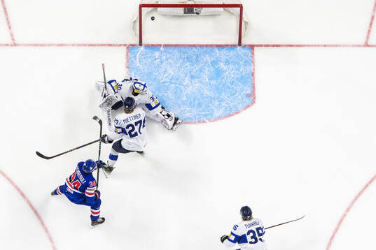 Cole Hutson of USA scores 3-3 behind Julius Miettinen and