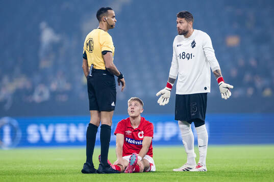 Degerfors Elias Pihlström har ont och AIKs målvakt Kristoffer Nordfeldt reagerar mot domare Farouk Nehdi