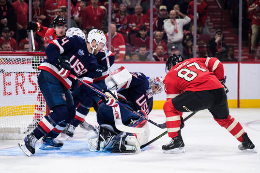 Jaccob Slavin and goaltender Connor Hellebuyck of USA are