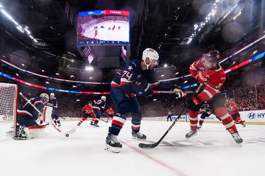 Goaltender Connor Hellebuyck and Jaccob Slavin of USA and