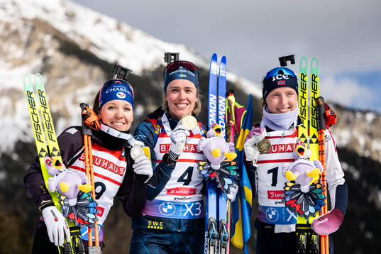 Silver medalist Oceane Michelon of France, gold medalist Elvira Öberg of Sweden and bronze medalist Maren Kirkeeide of Norway pose with their medals after women's 12,5 km mass start