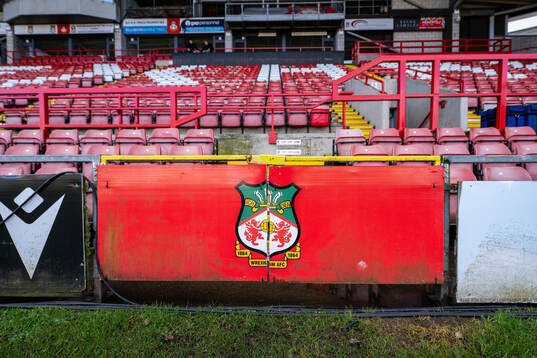 The club Crest of Wrexham is seen below stands at Racecourse Ground