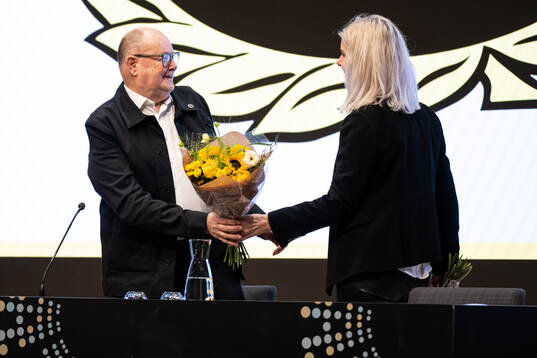 Mötesordförande Pelle Höög får blommor