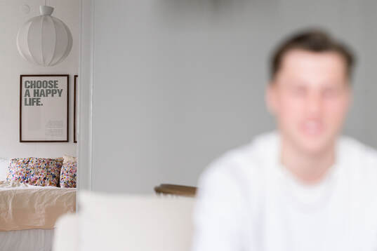 En tavla med texten Choose A Happy Life på väggen hemma