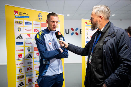 Goalkeeper Robin Olsen of Sweden and sport reporter Olof Lundh in the mixed zone