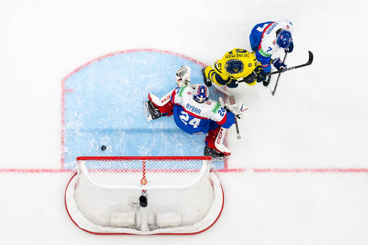 Emil Heineman of Sweden with goaltender Patrik Rybar and Mario Grman of Slovakia as Elias Lindholm of Sweden (not pictured) score 4-0