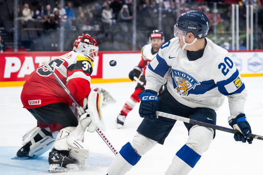 Goaltender Atte Tolvanen of Austria saves a shot from Eeli