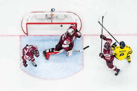 Jonas Brodin of Sweden and Haralds Egle, goalkeeper