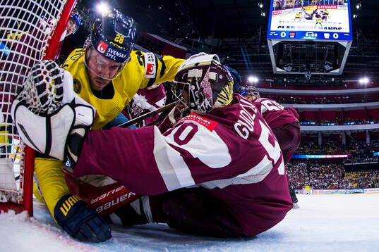 Elias Lindholm of Sweden and goaltender Kristers Gudlevskis