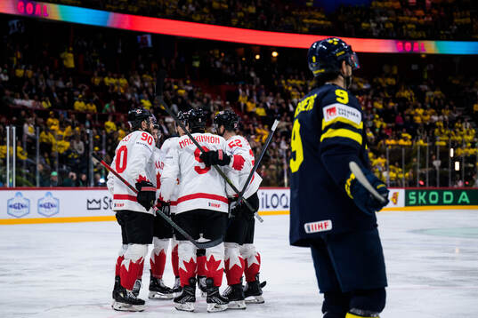 Nathan MacKinnon of Canada celebrates with teammates after scoring the 2-5 goal