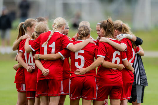 Spelare från lag 3 samlas i en ring