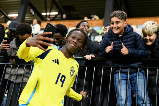 Alieu Njie of Sweden takes photos with the fans