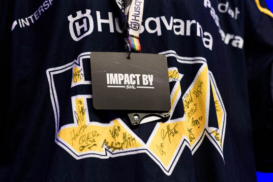 En bricka med Impact by SHL hänger på en signerad