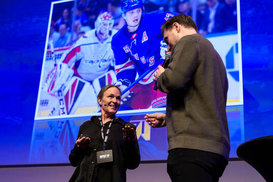 Moderator Frida Boklund lämnar över en puck till Jesper