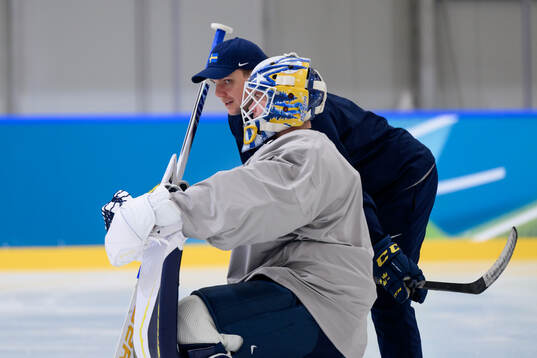 Goalkeeper coach Anthon Hansson speaks to goaltender Jesper