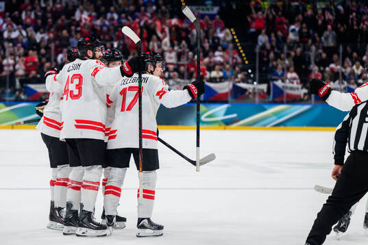 Macklin Celebrini of Canada celebrate with teammates