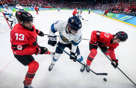 Sam Reinhart and Macklin Celebrini of Canada against Miro