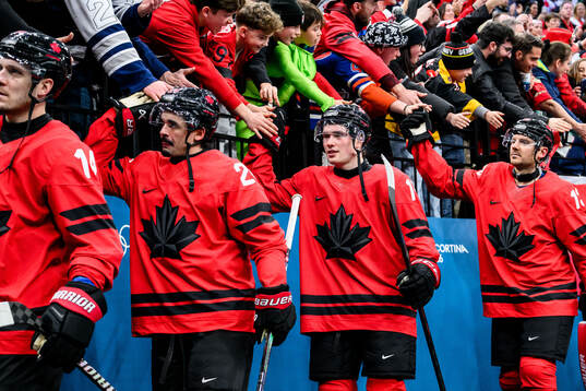 Macklin Celebrini of Canada celebrate with fans