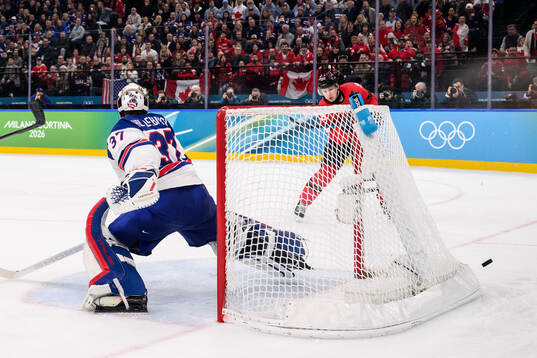 Nathan MacKinnon of Canada and goaltender Connor Hellebuyck
