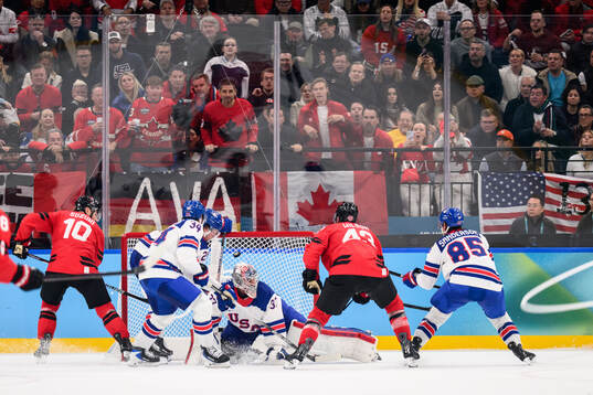 Nick Suzuki and Tom Wilson of Canada against goaltender