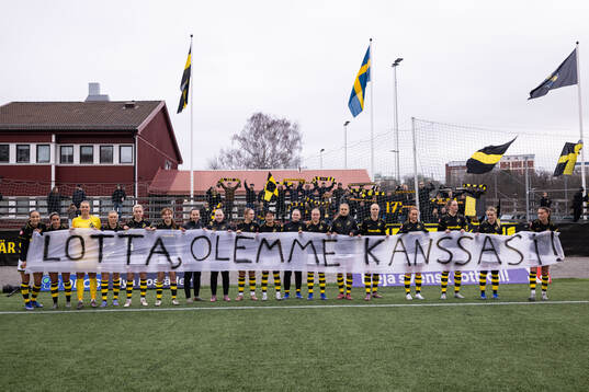 AIKs spelare med en banderoll