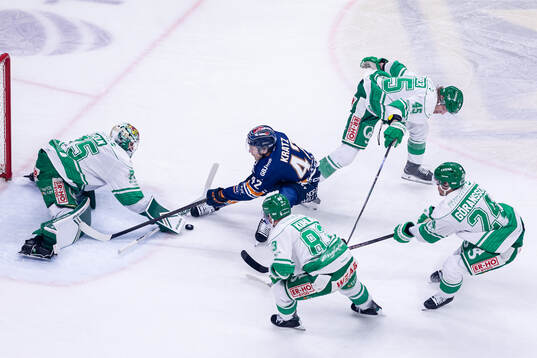 Växjös Kalle Kratz mellan Rögles målvakt Arvid Holm,